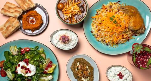 Vorspeisen von oben: Hummus mit Brot, Joghurt-Dips und Auberginen, daneben Safran-Reis und Salat