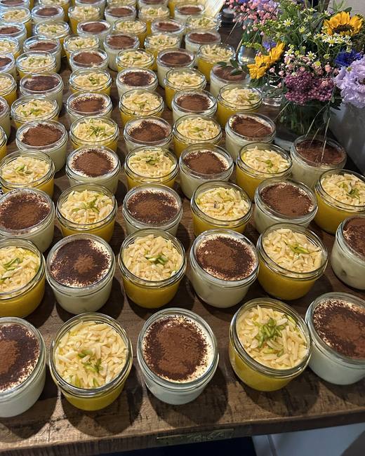 Viele Desserts im Glas auf einem langen Holztisch