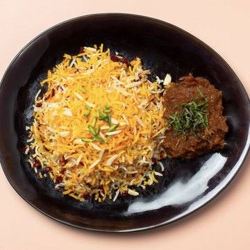 Zereshkpolo vegan mit Mirza Ghasemi auf einem schwarzen Teller